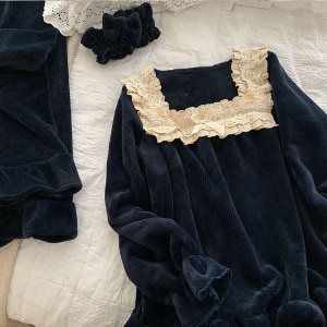 Vintage pyjamaset med svart spets på sängen