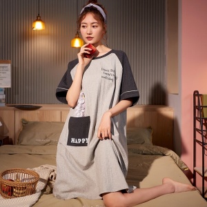 Pyjamas av bomull med texten HAPPY som bärs av en kvinna