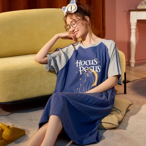 Pyjamas i bomull med katttryck för kvinnor som bärs av en kvinna som sitter på en matta i ett hus