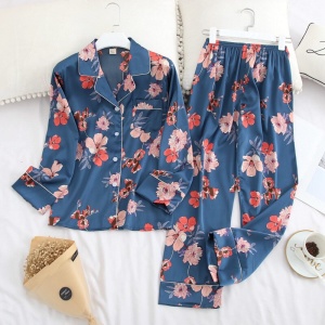 Blå tvådelad pyjamas med långa ärmar och en modern blommig design på ett bälte
