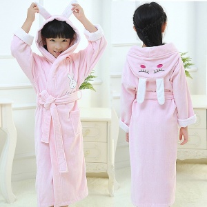 Högkvalitativ rosa bomullspyjamas med kanin för flickor som bärs av en liten flicka i ett hus
