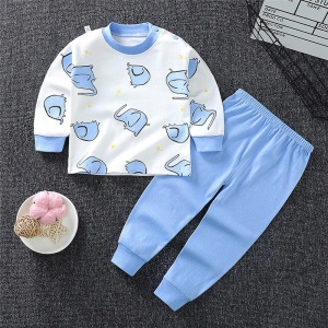 Pyjamas av elefantbomull för liten pojke med blåa byxor på en matta i ett hus