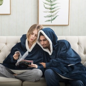 Sweat Plaid - Den ultrakomfortabla svettplaid för par som bärs av ett par som sitter i en soffa i ett hus