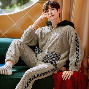 Varm pyjamas med huva för män som bärs av en man som sitter på en stol i ett hus