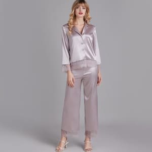 Snyggt pyjamaset med spets och satin för kvinnor som bärs av en moderiktig kvinna