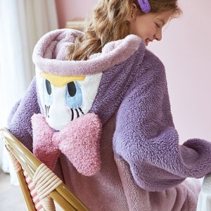 Lila och rosa Disney-jumpsuit med en leende kvinna i pyjamas