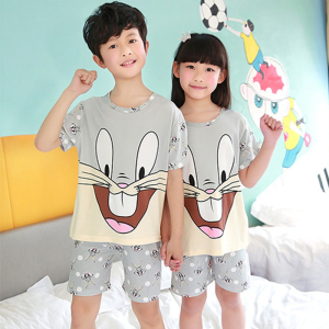 Grå kortärmad sommarpyjamas med Bugs Bunny-mönster för barn som bärs av barn i ett hus