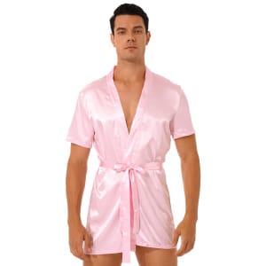 mörkhårig man stående i rosa kimono pyjamas av satin som är knuten i midjan med ett bälte