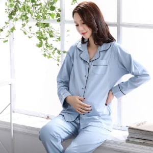 Klassisk blå graviditetspyjamas med svarta detaljer med en kvinna som bär pyjamasen