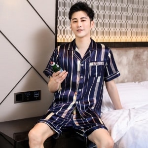 Kortärmad lyxig pyjamas för män med vikta krage med en man i pyjamas med sovrumsbakgrund