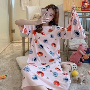 Kortärmad pyjamas med Elmo-tryck som bärs av en kvinna i ett hus