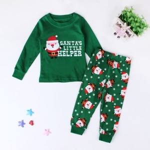 Santa's little helpers" grön pyjamas med vit bakgrund och en växt med stjärnor