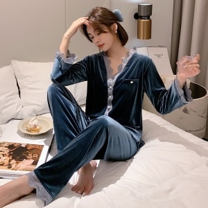 Varm pyjamas med V-hals med en kvinna som bär pyjamasen i sängen