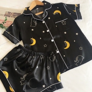Sommar pyjamas i svart stjärnhimmel satin med vit bakgrund och tidning