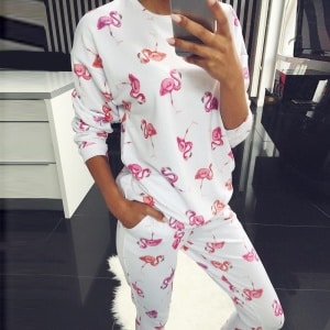 Varm pyjamas med exotiskt vitt och rosa mönster med en kvinna i pyjamasen