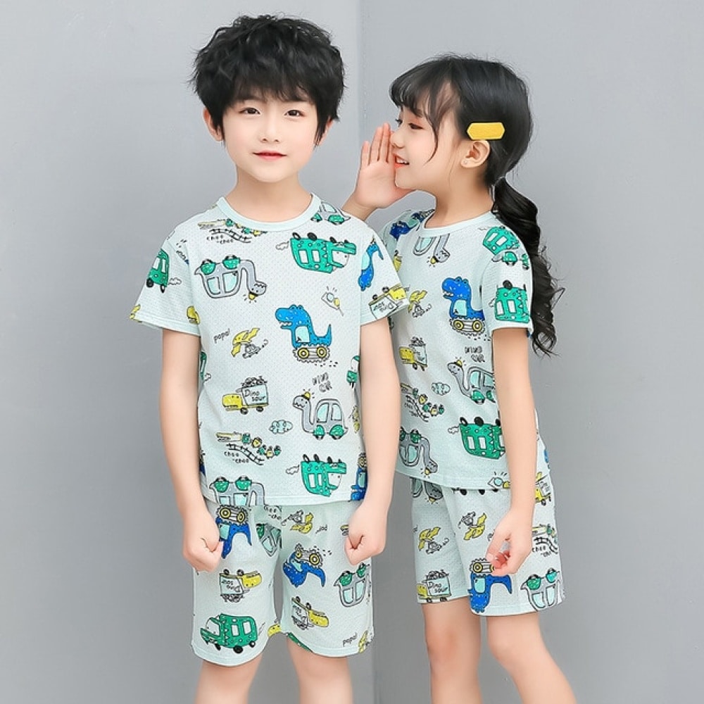 Grön tvådelad pyjamas med tecknat tryck för barn med två barn i pyjamas och grå bakgrund