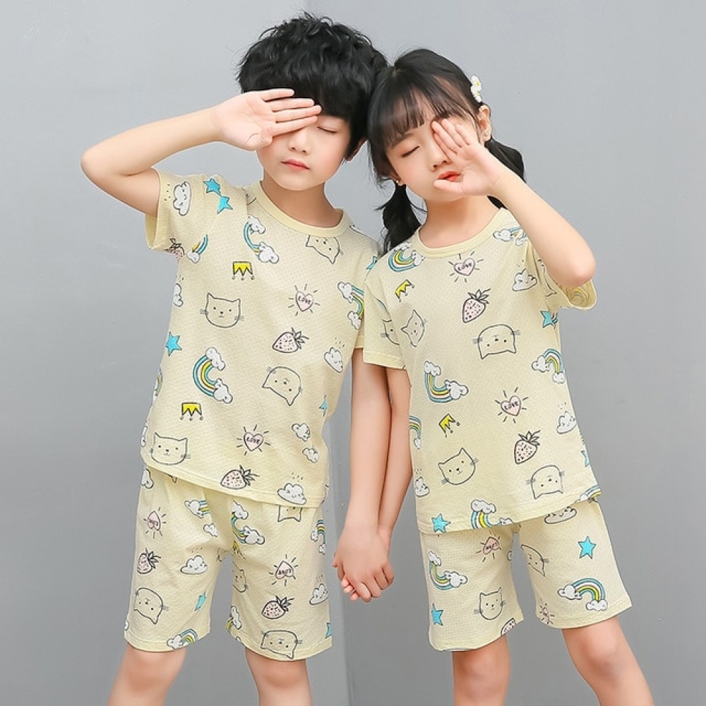 Vit tvådelad pyjamas med tecknat mönster för barn med två barn i pyjamas och grå bakgrund