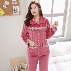 Pyjamaset i varm fleece för kvinnor som bärs av en kvinna i ett hus