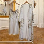 Sexig grå pyjamas med blommigt tryck hängande på en galge i ett rum med trägolv och vit vägg framför en stor spegel med gyllene ram
