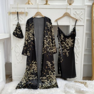 Sexig svart pyjamas med blommigt tryck hängd på galgar framför en vit vägg med lister och på en vit pälsduk