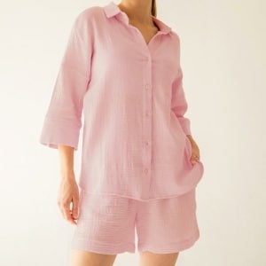 ung flicka i rosa pyjamas bestående av en halvärmad tröja och matchande shorts