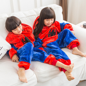 Två barn i soffan med blått och rött spiderman pyjamaset